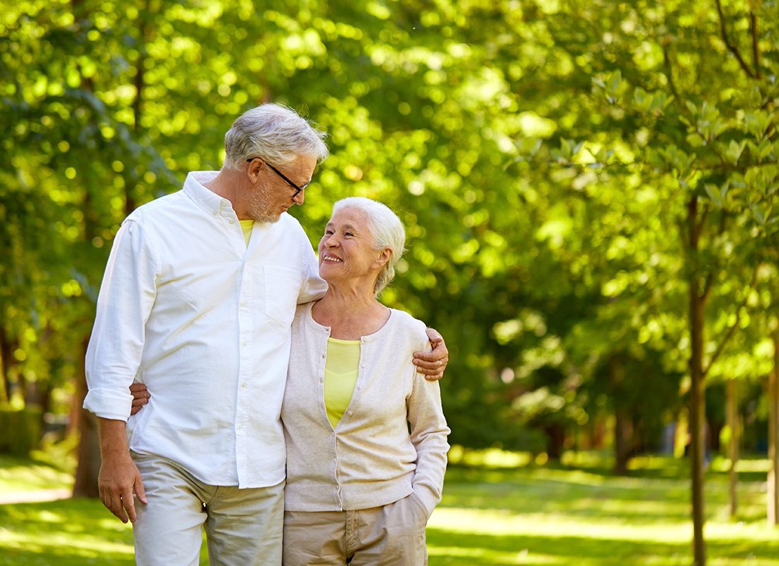 Medicare - Loving Older Couple Taking a Walk in a Park on Sunny Day