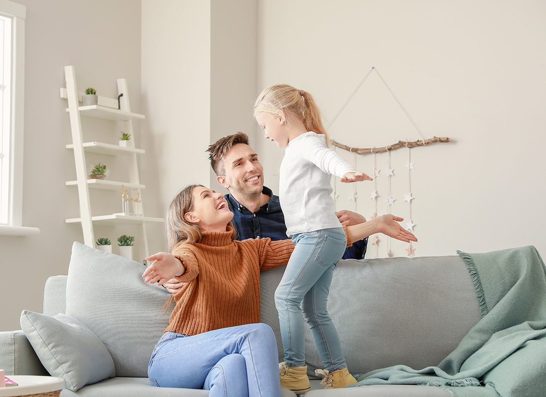 Personal Insurance - Happy Mother and Father Playing With Their Young Daughter at Home